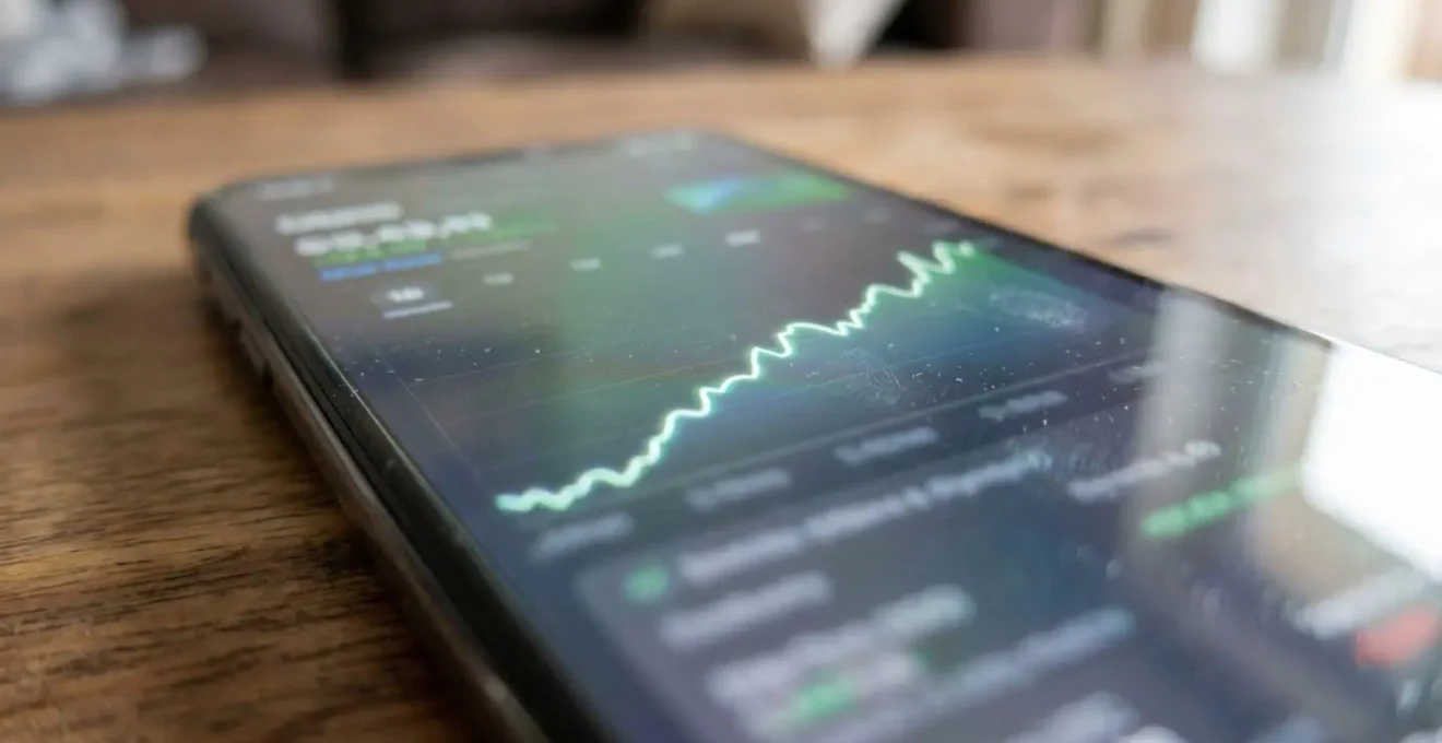 Écran de smartphone moderne affichant un graphique de courbe ascendante sur fond de surface en bois clair